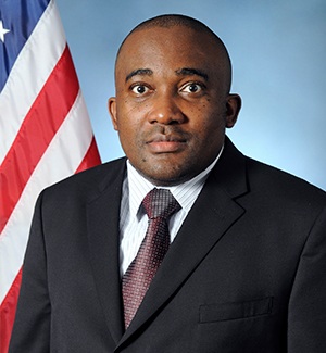 Charles A. Kamhoua  by the American flag